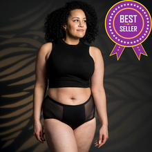 Load image into Gallery viewer, A woman is wearing Heralogie&#39;s black heavy absorbency period underwear. There are 2 mesh panels flanking a center panel which contains the gusset, or the absorbent center area. The absorbent fabrics line the underwear all the way up to the waistband on both sides.This reusable, sustainable, leak-proof period underwear is premium quality, comfy, and holds up to 4 tampons of blood. Perfect gift for girls. It&#39;s great to wear at night or during days with heavy flow.
