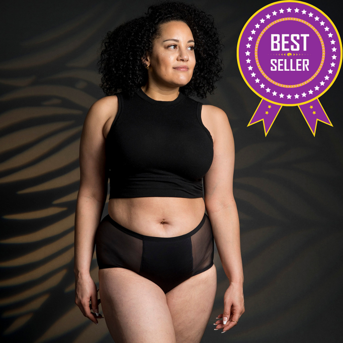 A woman is wearing Heralogie's black heavy absorbency period underwear. There are 2 mesh panels flanking a center panel which contains the gusset, or the absorbent center area. The absorbent fabrics line the underwear all the way up to the waistband on both sides.This reusable, sustainable, leak-proof period underwear is premium quality, comfy, and holds up to 4 tampons of blood. Perfect gift for girls. It's great to wear at night or during days with heavy flow.